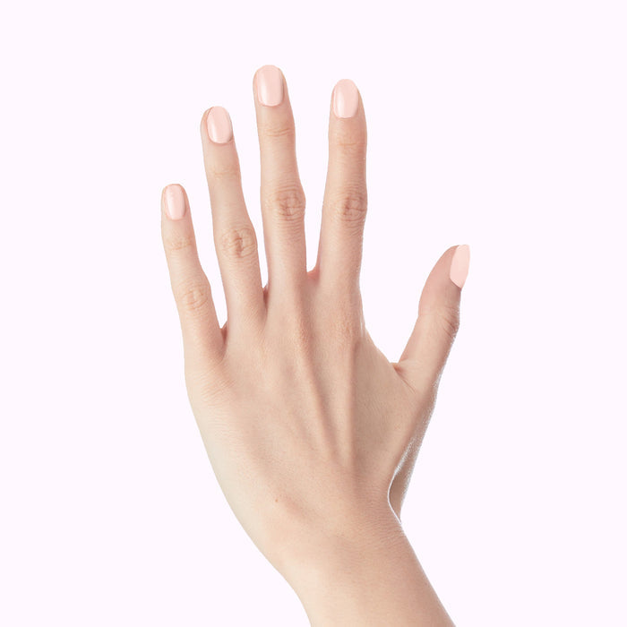 GH - Press-On | Extra Short | Round hand wearing glossy opaque glowy baby pink false nails for at-home manicure look