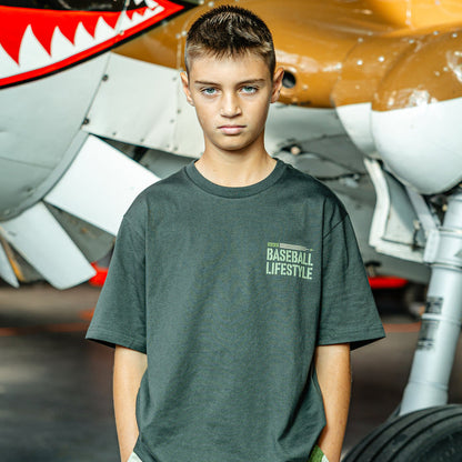 Youth Dark Grey T- shirt with green lettering that says 'BASEBALL LIFESTYLE' in the top right corner on person