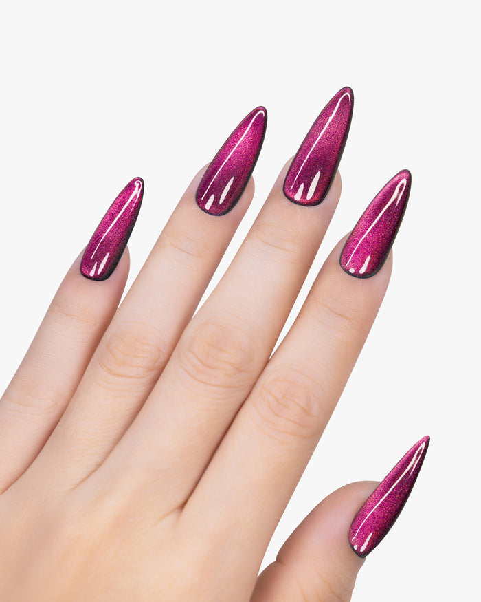 Hand with pink glittery nail polish on a white background