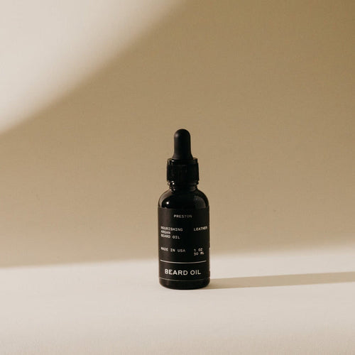 Dark amber beard oil bottle with black dropper cap and label