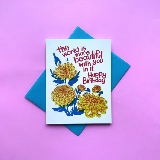 Birthday greeting card with blue letterpress text and yellow mum flower illustration
