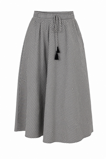 A black and white micro-check patterned midi skirt with a drawstring waist and a black tassel accent, shown against a plain white background.