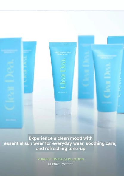 Blue tubes and boxes of Clear Dea. Pure Fit Tinted Sun Lotion arranged on a reflective white surface with promotional text at the bottom.