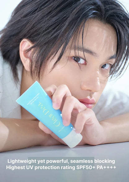 A close-up lifestyle shot of a young man resting his head on his arms, holding a light blue tube of Clear Doll sunscreen. Text at the bottom reads: 'Lightweight yet powerful, seamless blocking Highest UV protection rating SPF50+ PA++++'.