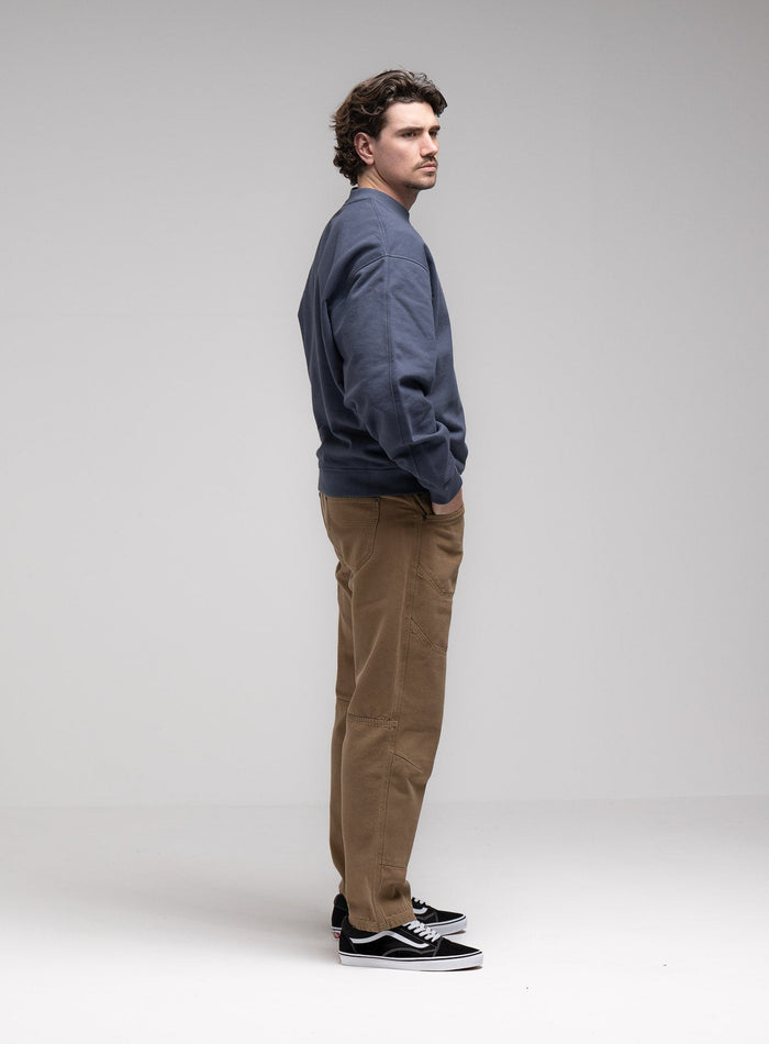 Jack Is 6ft 3" And Wears Size: L | Hem Studio Image Of Model Wearing Dissident Jumper In Storm Blue (SS Model)