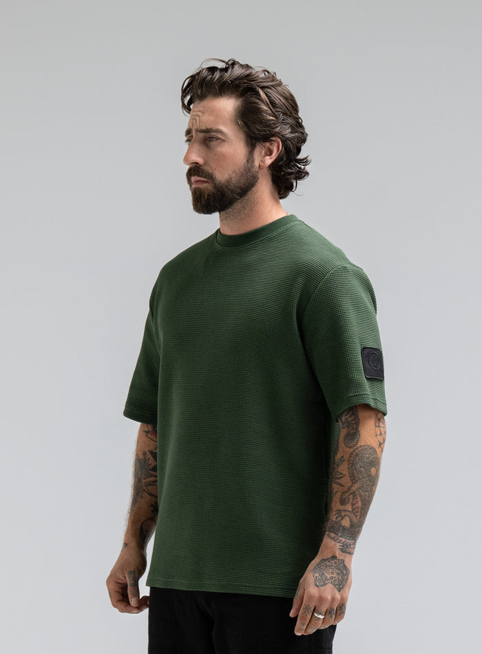 Max Is 5ft 8" And Wears Size: M | Hem Studio Image Of Model Wearing Dissident Waffle Short Sleeve T-Shirt In Forest Green (SS Model)