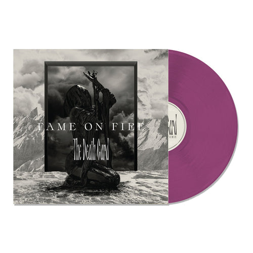 A purple vinyl record partially slides out of its album cover, which features a dark, cloaked figure with raised arms in a mountainous landscape. This limited edition release displays Fame On Fire and The Death Card in bold lettering.