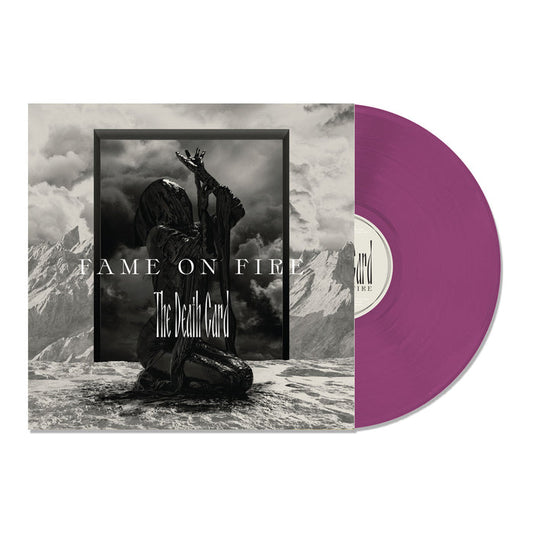 A purple vinyl record partially slides out of its album cover, which features a dark, cloaked figure with raised arms in a mountainous landscape. This limited edition release displays Fame On Fire and The Death Card in bold lettering.