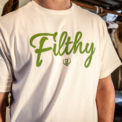 Beige T-shirt with olive green ‘Filthy’ lettering and BL101 logo across chest on person.