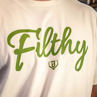 Close up of Youth Beige T-shirt with olive green ‘Filthy’ lettering and BL101 logo across chest.