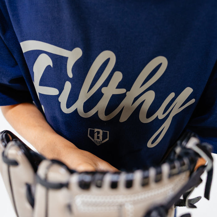 Person wearing a blue shirt with 'Filthy' printed on it, holding a baseball glove.