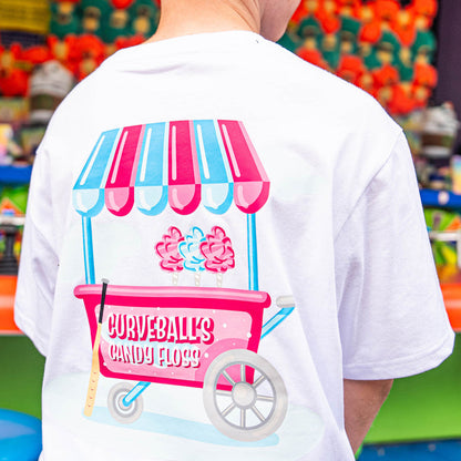 Person wearing a white t-shirt with a candy floss cart design in front of a colorful background.