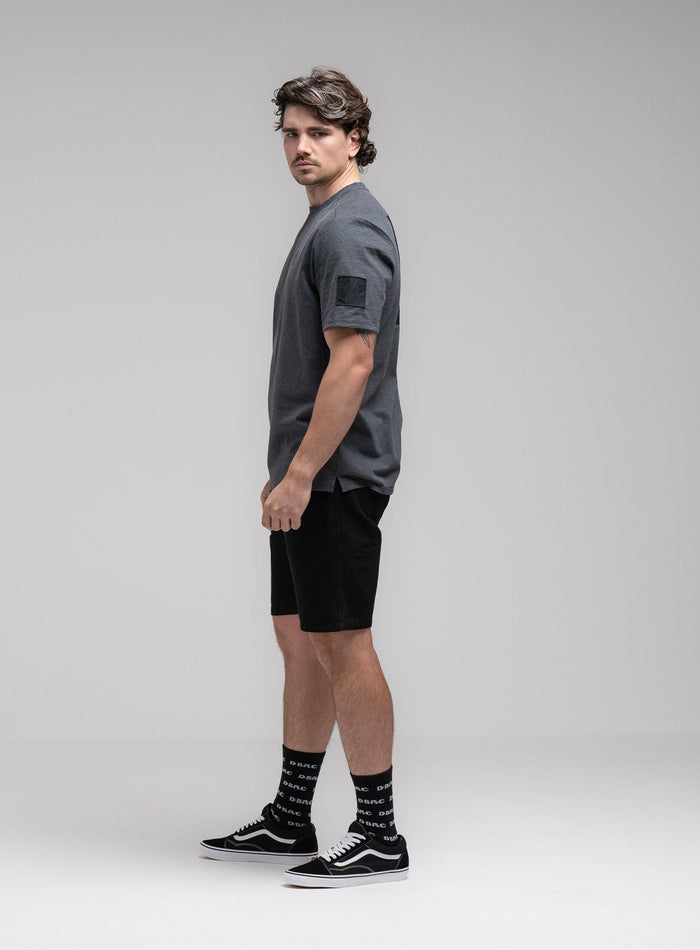 Jack Is 6ft 3" And Wears Size: L | Hem Studio Image Of Model Wearing Insignia T-Shirt - Black Mark In Charcoal Grey (SS Model)