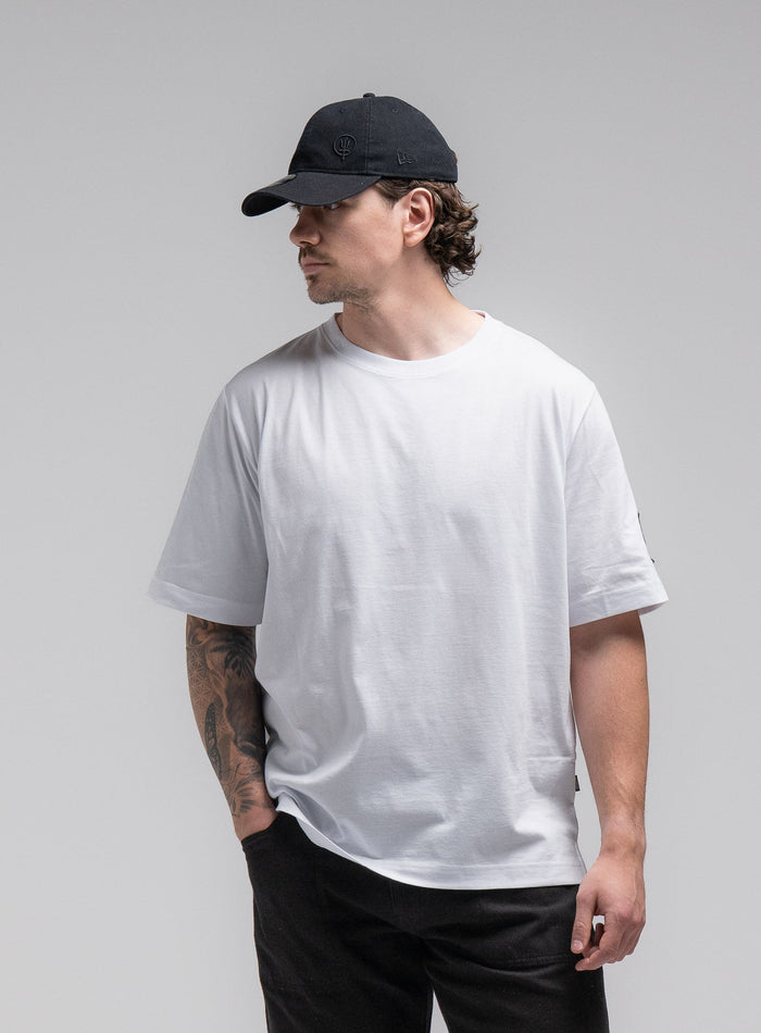 Jack Is 6ft 3" And Wears Size: L | Hem Studio Image Of Model Wearing Jackal T-Shirt In Optic White (SS Model)