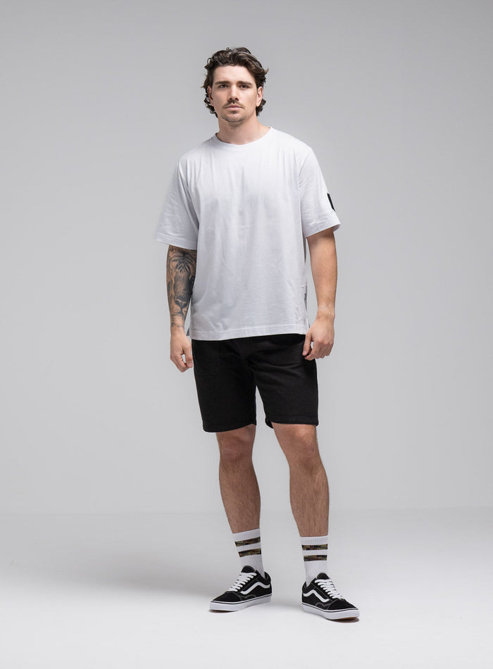 Jack Is 6ft 3" And Wears Size: L | Hem Studio Image Of Model Wearing Jackal T-Shirt In Optic White (SS Model)