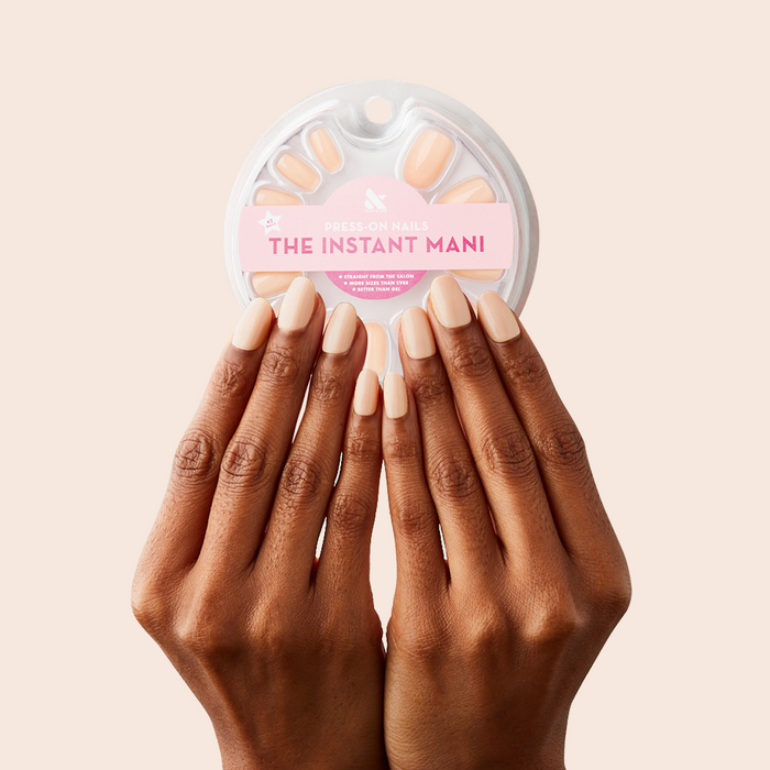 KAG - Press-On | Short | Round hands with neutral peachy pink round nails holding press-on nail set packaging