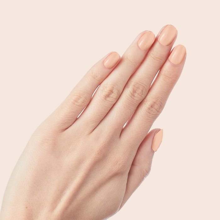 KAG - Press-On | Short | Round hand with soft peachy pink short round false nails for a classic manicure look