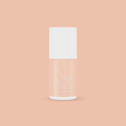 KAG nail polish bottle in neutral peachy pink shade on matching peach background for a fresh mani or pedi