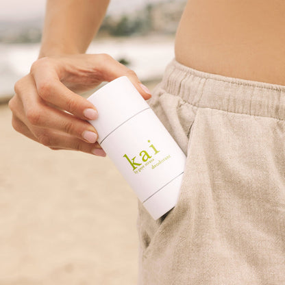 Kai deodorant stick, 2 oz, held in hand; white twist-up container