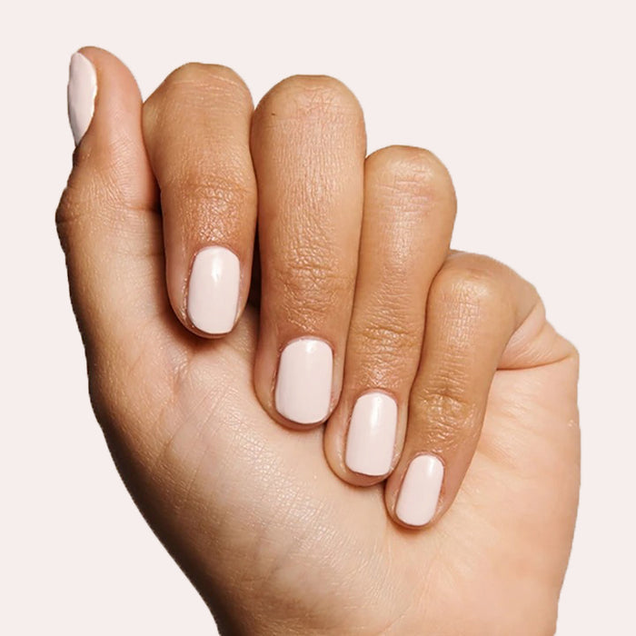Hand with LHG nail polish in a subtle pink neutral shade on neatly manicured nails against a light background
