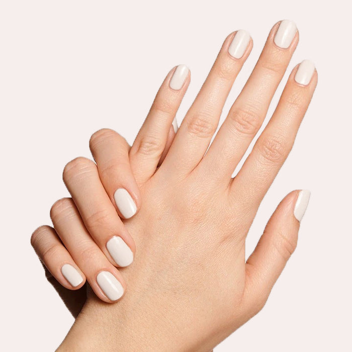 Neatly manicured hands with LHG polish in a fresh neutral shade featuring a subtle hint of pink for a classic mani