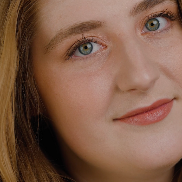 Close-up of a person with light brown hair and green eyes.