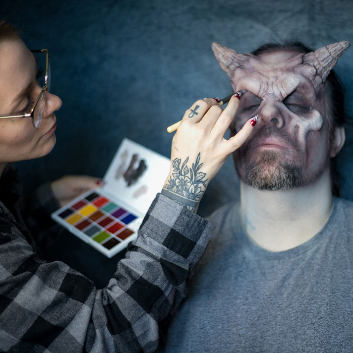 Makeup artist applying Master FX cream palette to demon character SFX makeup