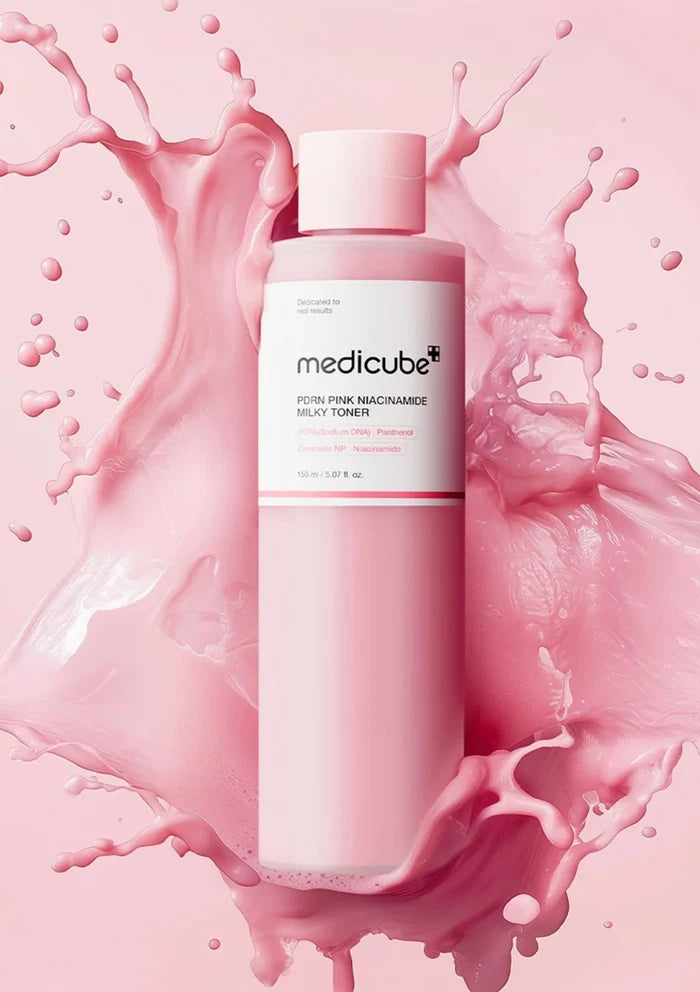 Medicube toner bottle with pink liquid splashes on a pink background