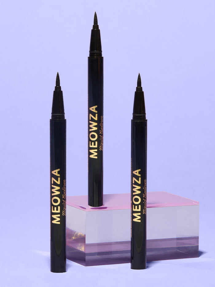 meowza liquid eyeliner standing on glass surface with purple background
