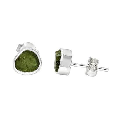 A pair of sterling silver stud earrings featuring rough Moldavite shown on a plain white background with one earring facing forward and the other showing the side profile and post backing.