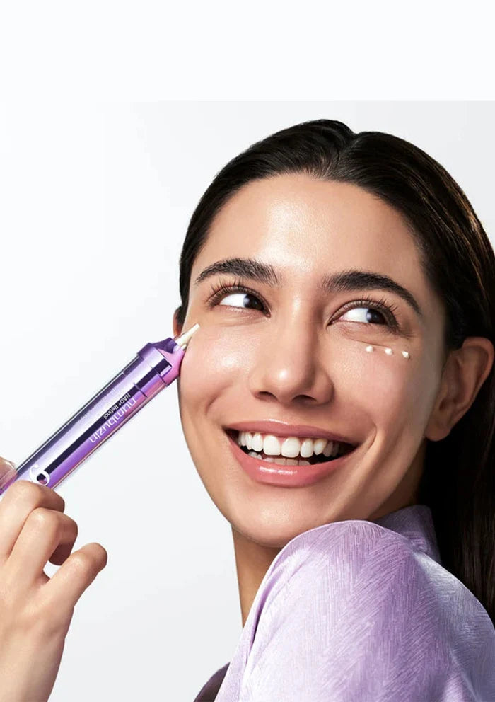 Woman applying a cosmetic product to her face with a white background