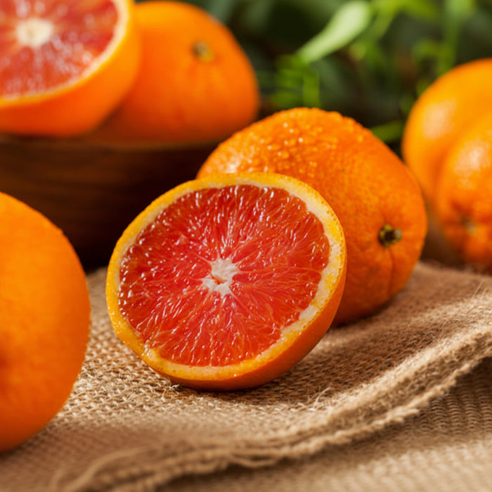 Oranges with a close-up of a halved orange revealing its juicy interior.
