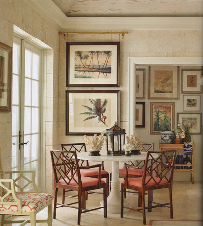 Dining room with a table and chairs, framed artwork on the wall, and a decorative lamp.