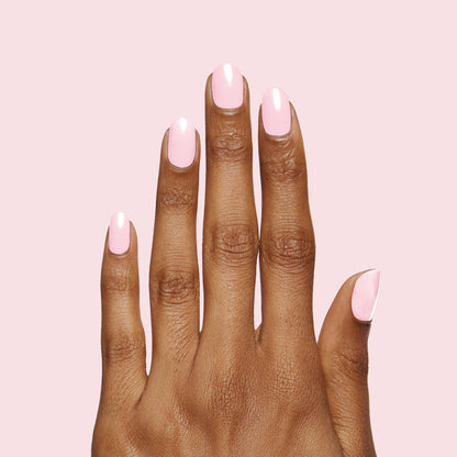Hand with nails painted in soft rose pink Rosy Tips gel polish on light pink background showing manicure quality