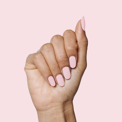 Hand with nails painted in soft rose pink Rosy Tips gel polish on pale pink background showing manicure quality