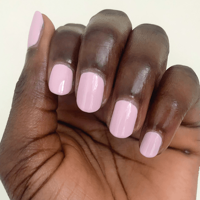 Hand with nails painted in glossy Rosy Tips gel polish showing a fresh and neat manicure on dark skin tone