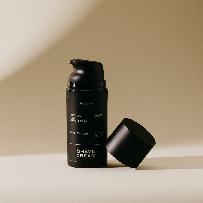 Shave cream aerosol canister with open cap, black bottle labeled PRESTON and AMBER