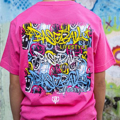 Youth model wearing pink youth graphic tee with “Smiley Slugger” design