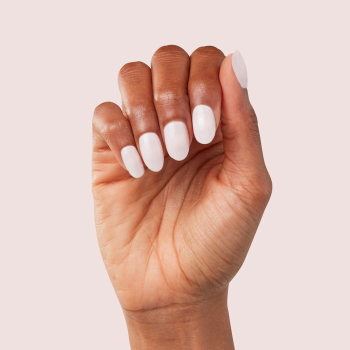 Hand with Strawberry Scone - Press-On | XS | Round featuring extra-short, semi-sheer pale pink press-on manicure
