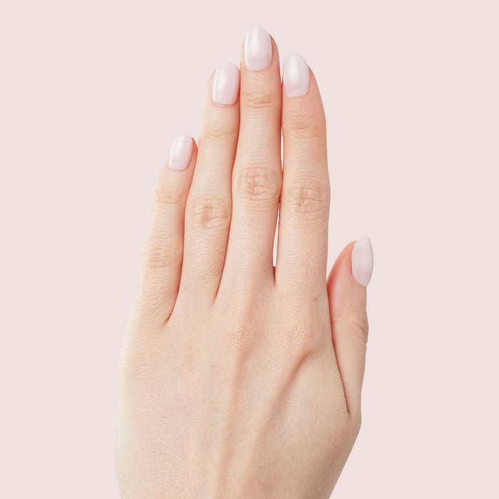 Hand showing Strawberry Scone - Press-On | XS | Round with extra-short, semi-sheer pink false nails manicure style