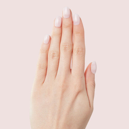 Hand showing Strawberry Scone - Press-On | XS | Round with extra-short, semi-sheer pink false nails manicure style