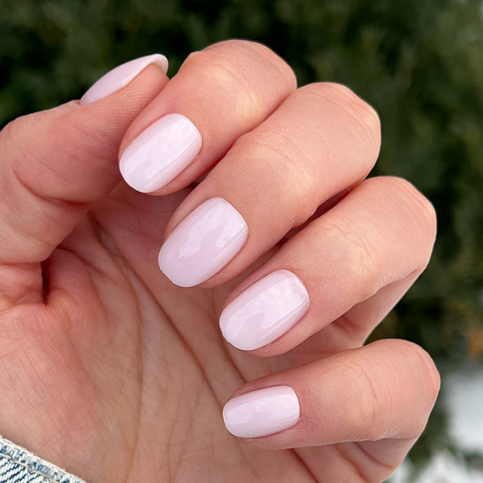 Hand displaying Strawberry Scone - Press-On | XS | Round with glossy extra-short, semi-sheer pink false nails manicure style