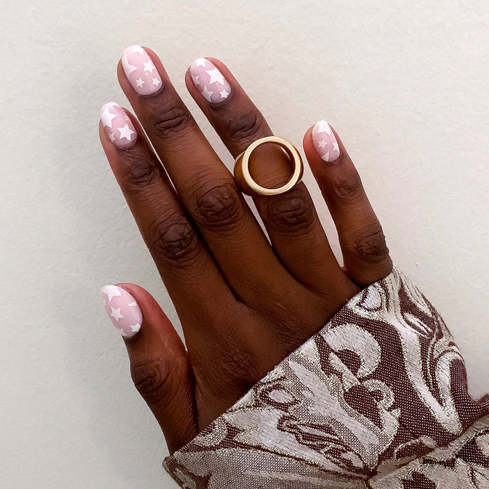 Super Stars - Press-On | Short | Round hand with short round false nails featuring white star pattern on neutral pink base