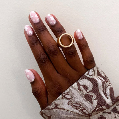 Super Stars - Press-On | Short | Round hand with short round false nails featuring white star pattern on neutral pink base
