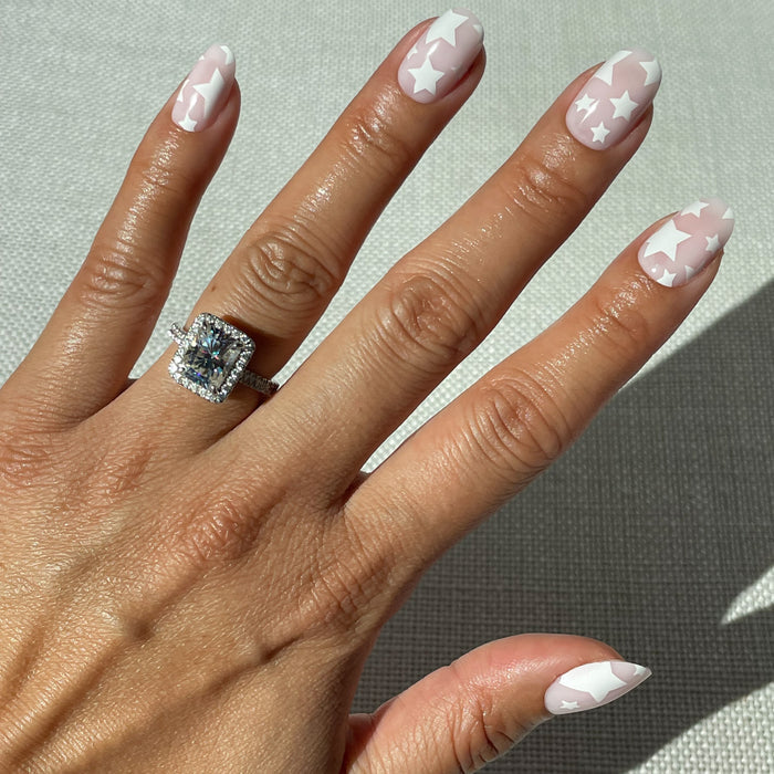 Super Stars - Press-On | Short | Round hand with neutral short round press-on nails featuring white star designs on natural skin tone