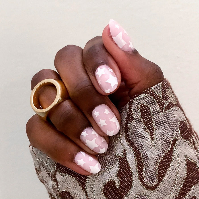 Super Stars - Press-On | Short | Round hand with round short false nails featuring white stars on a soft pink base