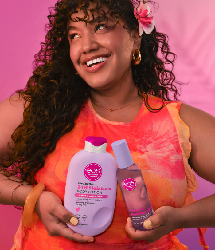 model holding two eos products on a pink background