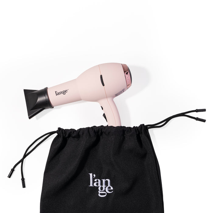 A pink hair dryer sticks out the top of the tool bag showing how large of a tool you can fit inside.