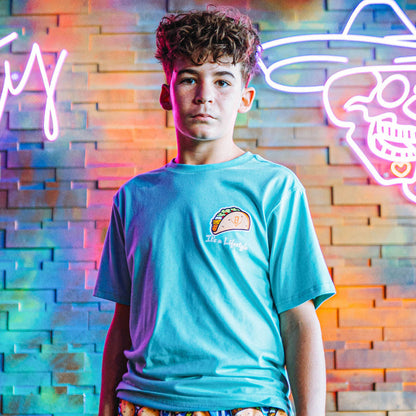 Person wearing teal t-shirt with a taco graphic design and 'It's a lifestyle' text
