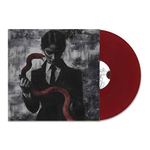 A limited edition maroon TX2 ‘Cruel World’ Oxblood LP partially slides from its cover, which displays dark art of a suited figure holding a red snake. The bold TX2 vinyl stands out against the textured black and gray backdrop.